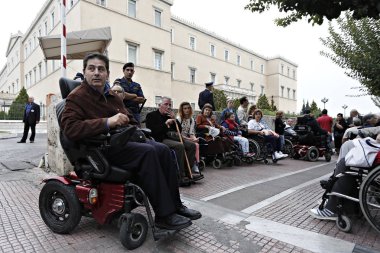 21 Ekim 2015'te Yunanistan'ın başkenti Atina'da yaşanan ekonomik krizde tasarruf tedbirlerine ilişkin korkular üzerine engelliler iş ve diğer haklar talep etmek için protesto gösterisi düzenlediler