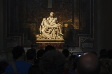 People stand in front of the Pieta which is a work of Renaissance sculpture by Michelangelo Buonarroti, housed in St. Peter's Basilica, Vatican City on April 27, 2019. clipart