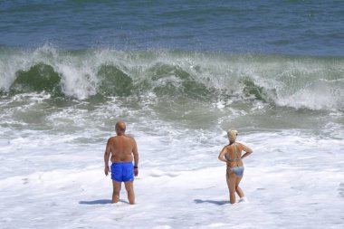 İnsanlar 10 Ağustos 2018'de Yunanistan'ın Agios Ioannis köyü sahilinde denizde yüzerken güneşli havanın tadını çıkarıyorlar.