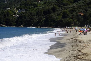 İnsanlar 10 Ağustos 2018'de Yunanistan'ın Agios Ioannis köyü sahilinde denizde yüzerken güneşli havanın tadını çıkarıyorlar.