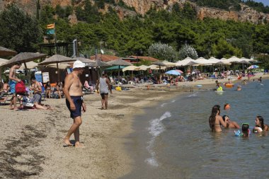 Yunanistan'ın Anavros sahilinde insanlar güneşlenmekte5 Ağustos 2018