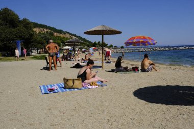 Yunanistan'ın Anavros sahilinde insanlar güneşlenmekte5 Ağustos 2018