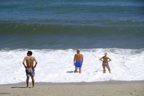İnsanlar 10 Ağustos 2018'de Yunanistan'ın Agios Ioannis köyü sahilinde denizde yüzerken güneşli havanın tadını çıkarıyorlar.