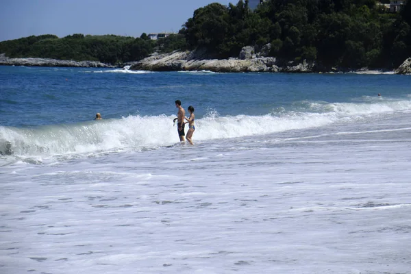 人々は 彼らが8月10 2018にギリシャのアギオスイオアニス村のビーチで海で泳ぐように晴れた天気を楽しみます — ストック写真