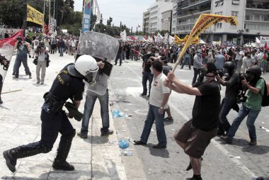 Polis ve göstericiler, 29 Haziran 2011 tarihinde Atina'da hükümetin politikası ve tasarruf kesintilerine karşı düzenlenen 48 saatlik genel grev sırasında Yunan parlamentosu önünde çatıştı.