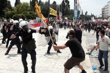 Polis ve göstericiler, 29 Haziran 2011 tarihinde Atina'da hükümetin politikası ve tasarruf kesintilerine karşı düzenlenen 48 saatlik genel grev sırasında Yunan parlamentosu önünde çatıştı.