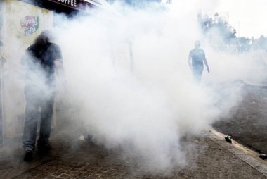 Polis ve göstericiler 28 Haziran 2011 tarihinde Atina'da hükümetin politikası ve kemer sıkma kesintilerine karşı 48 saatlik bir genel grev sırasında Yunan parlamentosu önünde çatışma