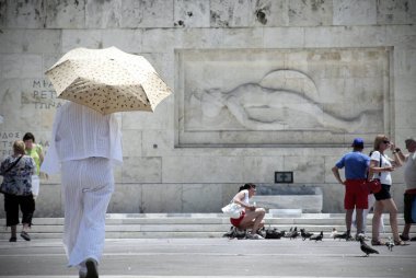 Atina'da sıcak hava dalgası sırasında Atina'nın merkezindeki sokakta yürüyen insanlar, 11 Temmuz 2017