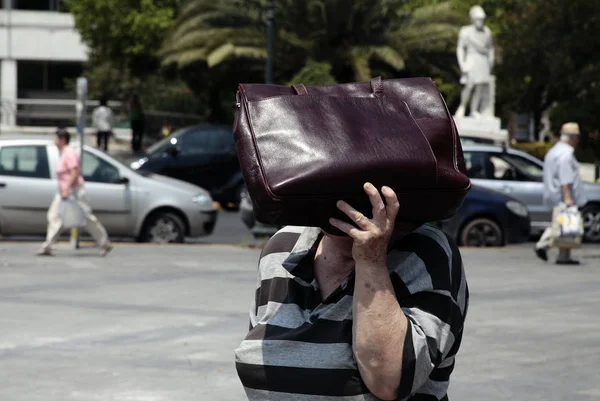 İnsanlar Temmuz'da Atina'da bir sıcak hava dalgası sırasında Atina'nın merkezi sokakta yürümek, Yunanistan 20, 2012