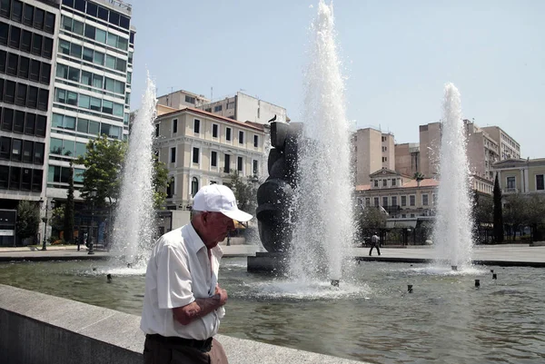 İnsanlar Temmuz'da Atina'da bir sıcak hava dalgası sırasında Atina'nın merkezi sokakta yürümek, Yunanistan 20, 2012