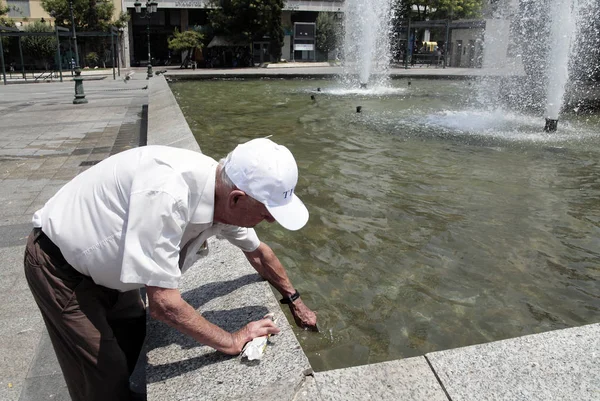 İnsanlar Temmuz'da Atina'da bir sıcak hava dalgası sırasında Atina'nın merkezi sokakta yürümek, Yunanistan 20, 2012