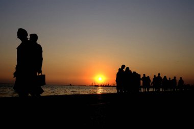 Yayalar sıcak bir yaz gün batımı sırasında sahil şeridinde yürümek, Ağustos'ta Selanik kuzey Yunanistan kentinde 22, 2019.