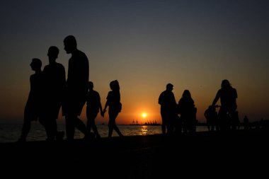 Yayalar sıcak bir yaz gün batımı sırasında sahil şeridinde yürümek, Ağustos'ta Selanik kuzey Yunanistan kentinde 22, 2019.