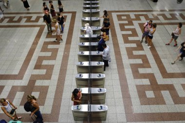 İnsanlar Atina'da metro tren istasyonu platformunda metro bileti doğrulama makineleri arasında yürümek, Yunanistan Ağustos'ta 9, 2019