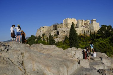 Turistler Atina'daki anıttan fotoğraf çekerken Akropolis tepesini ziyaret ettiler, Yunanistan 9 Ağustos 2019