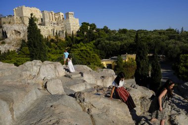 Turistler Atina'daki anıttan fotoğraf çekerken Akropolis tepesini ziyaret ettiler, Yunanistan 9 Ağustos 2019