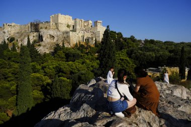 Turistler Atina'daki anıttan fotoğraf çekerken Akropolis tepesini ziyaret ettiler, Yunanistan 9 Ağustos 2019