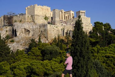 Turistler Atina'daki anıttan fotoğraf çekerken Akropolis tepesini ziyaret ettiler, Yunanistan 9 Ağustos 2019