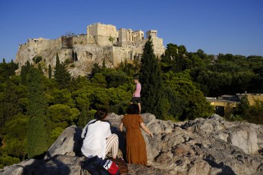 Turistler Atina'daki anıttan fotoğraf çekerken Akropolis tepesini ziyaret ettiler, Yunanistan 9 Ağustos 2019