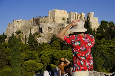 Turistler Atina'daki anıttan fotoğraf çekerken Akropolis tepesini ziyaret ettiler, Yunanistan 9 Ağustos 2019