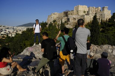 Turistler Atina'daki anıttan fotoğraf çekerken Akropolis tepesini ziyaret ettiler, Yunanistan 9 Ağustos 2019