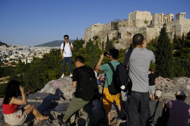 Turistler Atina'daki anıttan fotoğraf çekerken Akropolis tepesini ziyaret ettiler, Yunanistan 9 Ağustos 2019