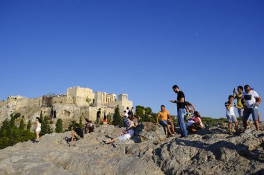 Turistler Atina'daki anıttan fotoğraf çekerken Akropolis tepesini ziyaret ettiler, Yunanistan 9 Ağustos 2019
