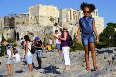 Turistler Atina'daki anıttan fotoğraf çekerken Akropolis tepesini ziyaret ettiler, Yunanistan 9 Ağustos 2019
