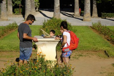 İnsanlar Atina Ulusal bahçede bir Sundial kontrol, Yunanistan Ağustos'ta 9, 2019