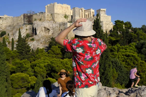 Turistler Atina'daki anıttan fotoğraf çekerken Akropolis tepesini ziyaret ettiler, Yunanistan 9 Ağustos 2019