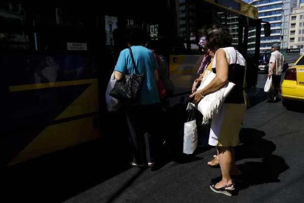 乗客は2019年8月8日にギリシャのアテネでバスに乗るのを待ちます — ストック写真