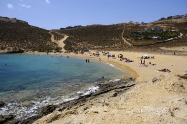 18 Ağustos 2019 tarihinde Yunanistan'ın Serifos Adası'ndaki Agios Sostis sahilinde güneşte yıkanan, yüzen ve oyun oynayan insanlar