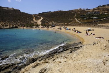 18 Ağustos 2019 tarihinde Yunanistan'ın Serifos Adası'ndaki Agios Sostis sahilinde güneşte yıkanan, yüzen ve oyun oynayan insanlar
