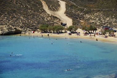 18 Ağustos 2019 tarihinde Yunanistan'ın Serifos Adası'ndaki Agios Sostis sahilinde güneşte yıkanan, yüzen ve oyun oynayan insanlar