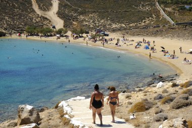 18 Ağustos 2019 tarihinde Yunanistan'ın Serifos Adası'ndaki Agios Sostis sahilinde güneşte yıkanan, yüzen ve oyun oynayan insanlar