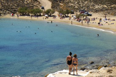 18 Ağustos 2019 tarihinde Yunanistan'ın Serifos Adası'ndaki Agios Sostis sahilinde güneşte yıkanan, yüzen ve oyun oynayan insanlar
