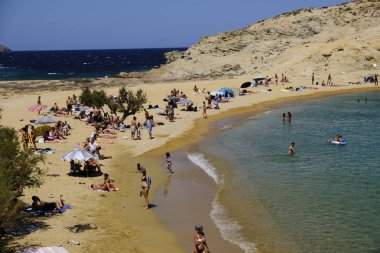 18 Ağustos 2019 tarihinde Yunanistan'ın Serifos Adası'ndaki Agios Sostis sahilinde güneşte yıkanan, yüzen ve oyun oynayan insanlar
