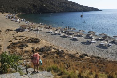 14 Ağustos 2019 tarihinde Yunanistan'ın Serifos Adası'ndaki Vagia sahilinde güneşte yıkanan ve yüzen insanlar