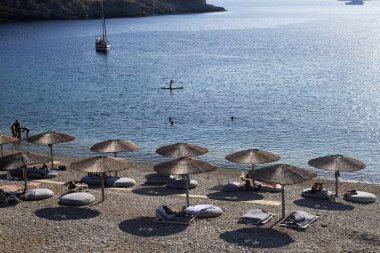 14 Ağustos 2019 tarihinde Yunanistan'ın Serifos Adası'ndaki Vagia sahilinde güneşte yıkanan ve yüzen insanlar