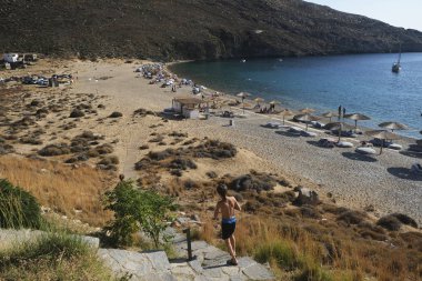 14 Ağustos 2019 tarihinde Yunanistan'ın Serifos Adası'ndaki Vagia sahilinde güneşte yıkanan ve yüzen insanlar