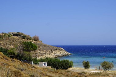 İnsanlar denizde banyo ve 13 Ağustos'ta Serifos Yunan Adası'nda Psili Ammos sahilde oyun oynarken
