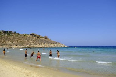 İnsanlar denizde banyo ve 13 Ağustos'ta Serifos Yunan Adası'nda Psili Ammos sahilde oyun oynarken