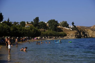 15 Ağustos 2019 tarihinde Yunanistan'ın Serifos Adası'ndaki Mikro Livadi sahilinde denizde yıkanan ve oyun oynayan insanlar