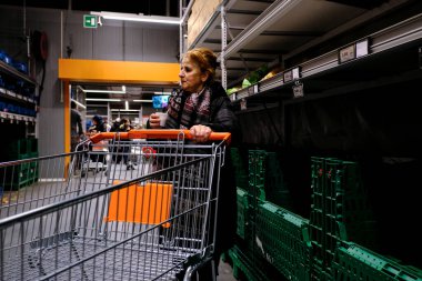 Brüksel, Belçika. 13 Mart 2020. Bir tüketici, Coronavirus hastalığı (COVID-19) salgını yüzünden marketin rafları boşalmaya başlarken eşyalara bakar (COVID-19). 