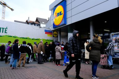 Belçika 'nın başkenti Brüksel' de 13 Mart 2020 'de meydana gelen Coronavirus hastalığı (COVID-19) salgını nedeniyle insanlar süpermarkete girmek için sıralarını bekliyorlar..