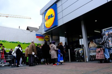 Belçika 'nın başkenti Brüksel' de 13 Mart 2020 'de meydana gelen Coronavirus hastalığı (COVID-19) salgını nedeniyle insanlar süpermarkete girmek için sıralarını bekliyorlar..