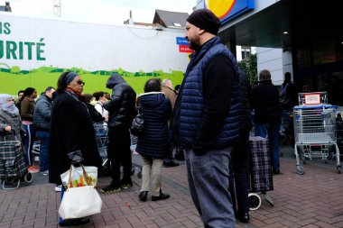 Belçika 'nın başkenti Brüksel' de 13 Mart 2020 'de meydana gelen Coronavirus hastalığı (COVID-19) salgını nedeniyle insanlar süpermarkete girmek için sıralarını bekliyorlar..