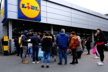 Belçika 'nın başkenti Brüksel' de 13 Mart 2020 'de meydana gelen Coronavirus hastalığı (COVID-19) salgını nedeniyle insanlar süpermarkete girmek için sıralarını bekliyorlar..