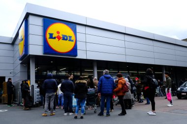 Belçika 'nın başkenti Brüksel' de 13 Mart 2020 'de meydana gelen Coronavirus hastalığı (COVID-19) salgını nedeniyle insanlar süpermarkete girmek için sıralarını bekliyorlar..