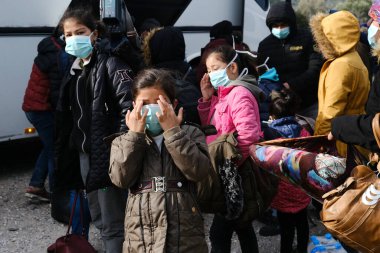 Göçmenler 4 Mart 2020 'de Yunanistan' ın Lezbiyen Adası 'ndaki Skala Sikamias köyünden Mytilene limanına nakledilmeyi bekliyorlar.. 